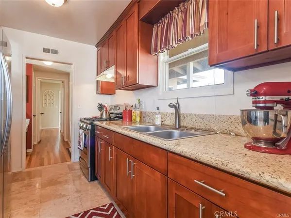 a kitchen with stainless steel appliances granite countertop a sink stove and cabinets