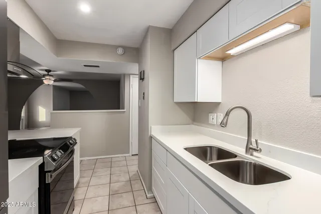 a kitchen with a sink and a stove top oven