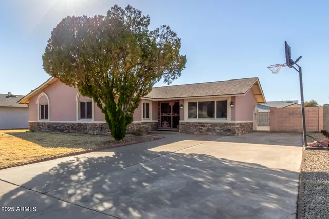 a house with yard and a trees in front of it