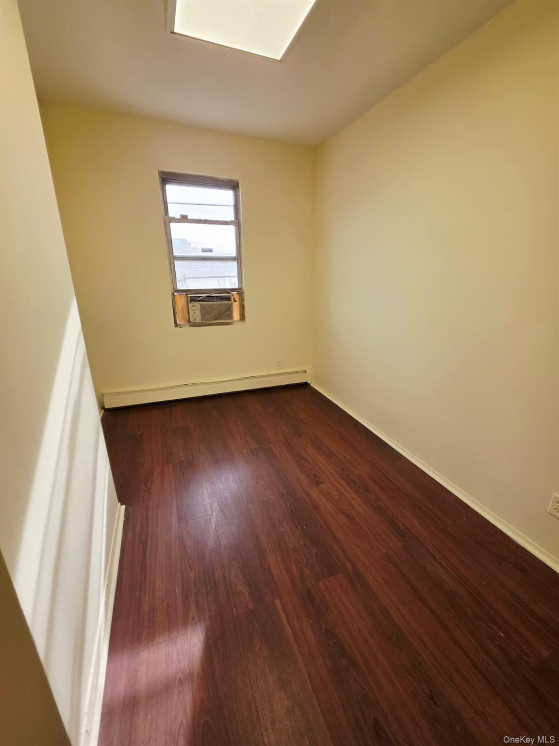 117-10 Jamaica Avenue, Unit 2A Queens, NY 11418 - Photo 2 of 4 an empty room with wooden floor and windows