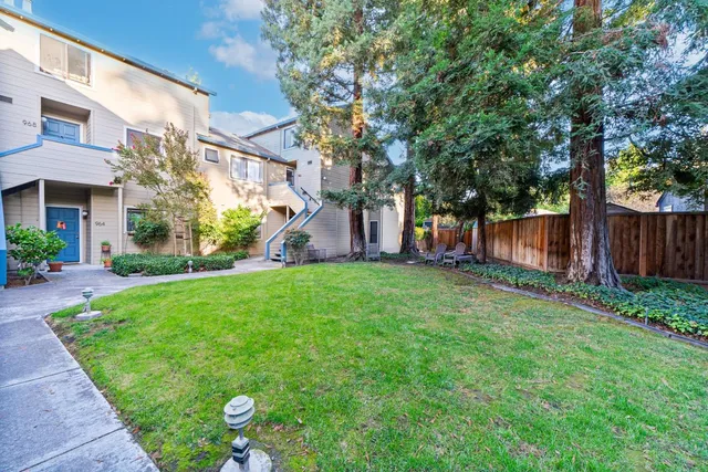 a view of a house with backyard and a tree