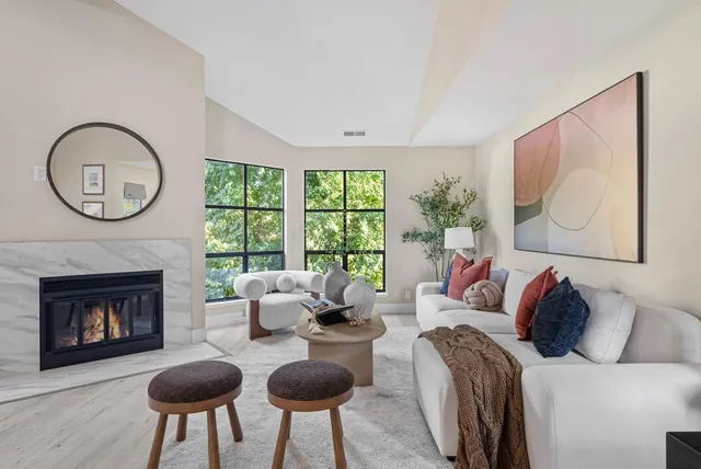 a living room with furniture a fireplace and a large window
