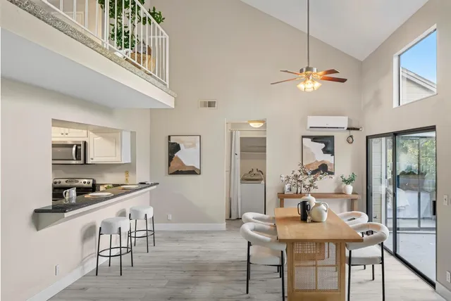 a view of a dining room with furniture a chandelier and wooden floor