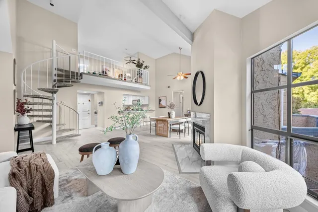 a living room with furniture a large window and a chandelier