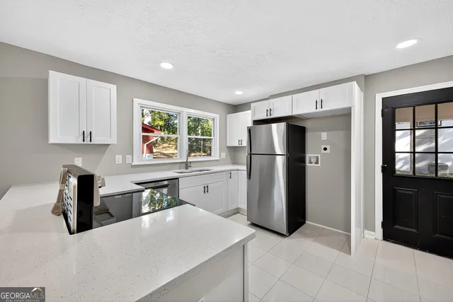 a kitchen with stainless steel appliances a refrigerator sink and cabinets