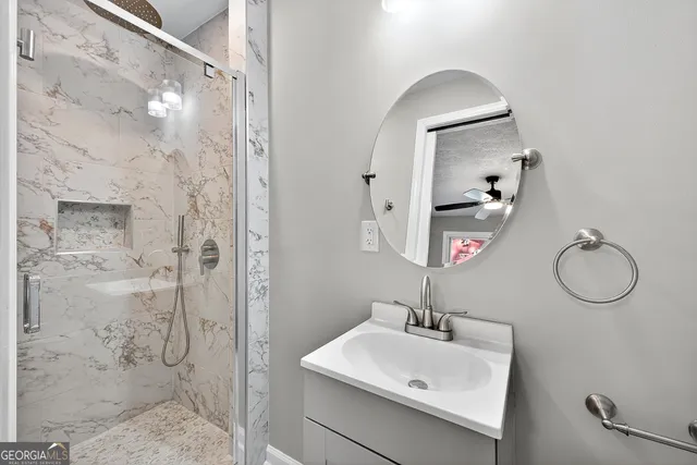 a bathroom with a sink mirror and shower
