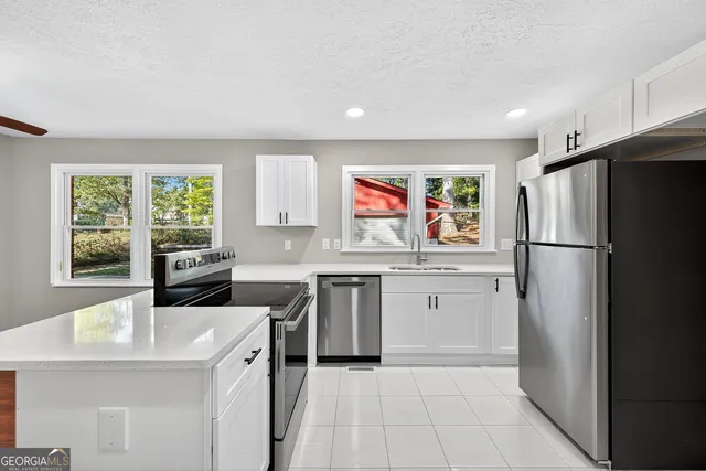 a kitchen with stainless steel appliances a refrigerator sink and stove