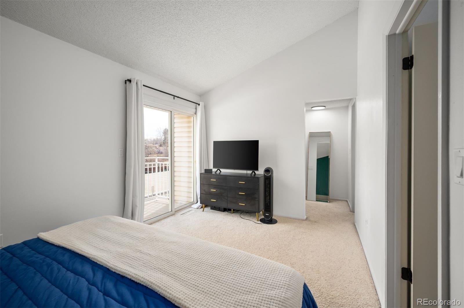 4367 East Maplewood Way Centennial, CO 80121 - Photo 15 of 26 a bedroom with a bed and a flat screen tv