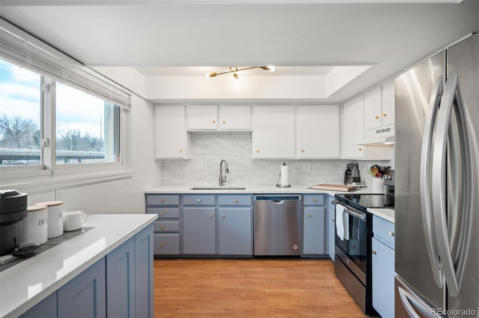 4367 East Maplewood Way Centennial, CO 80121 - Photo 4 of 26 a kitchen with stainless steel appliances a sink stove and refrigerator