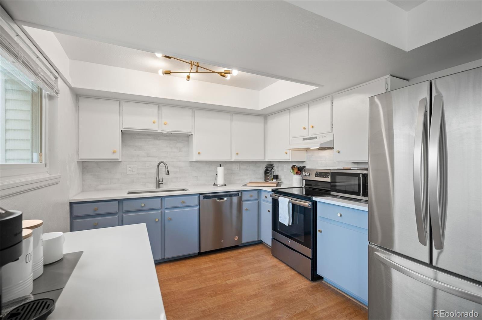 4367 East Maplewood Way Centennial, CO 80121 - Photo 5 of 26 a kitchen with stainless steel appliances granite countertop a refrigerator and a sink