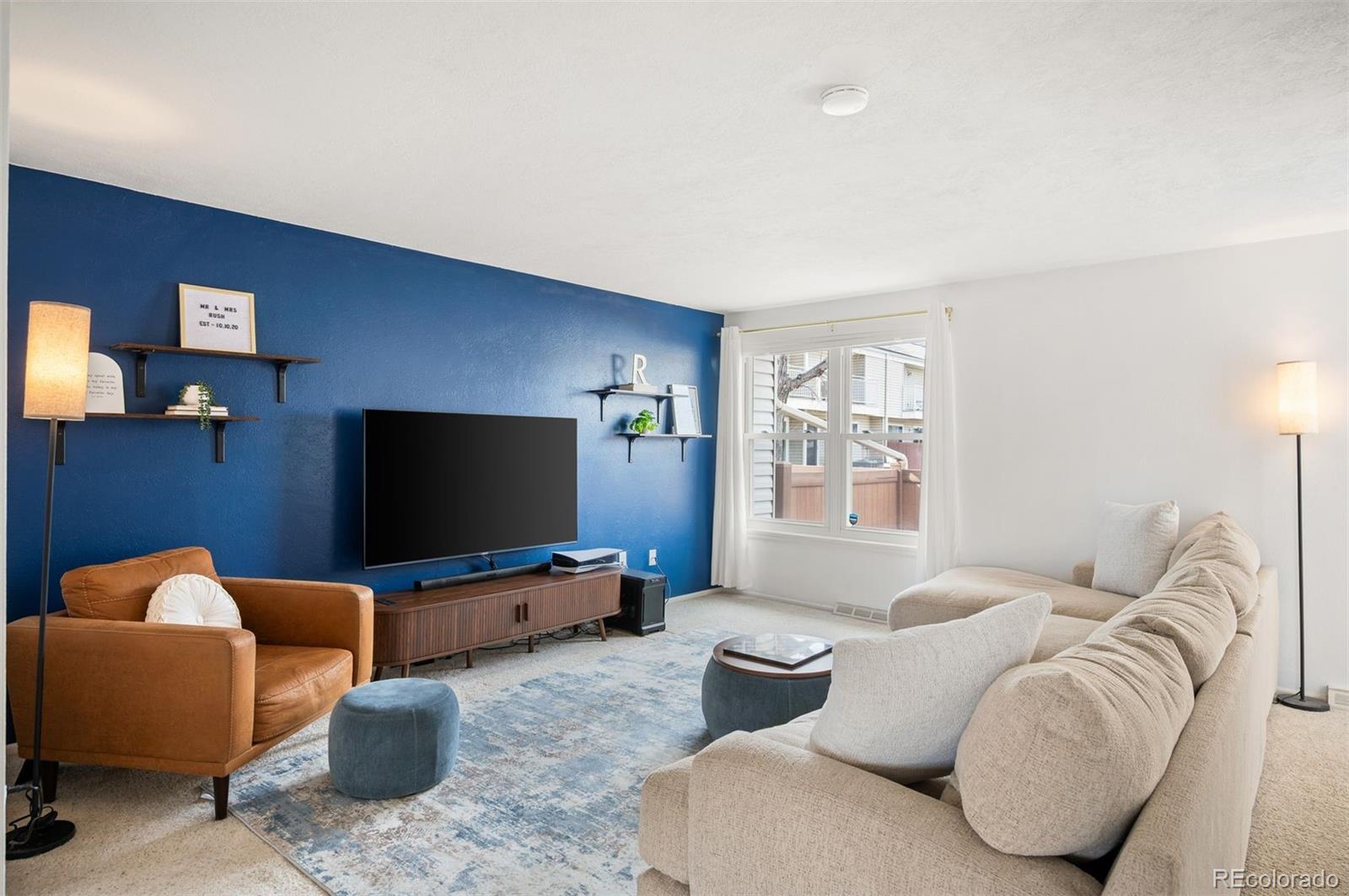 4367 East Maplewood Way Centennial, CO 80121 - Photo 9 of 26 a living room with furniture and a flat screen tv