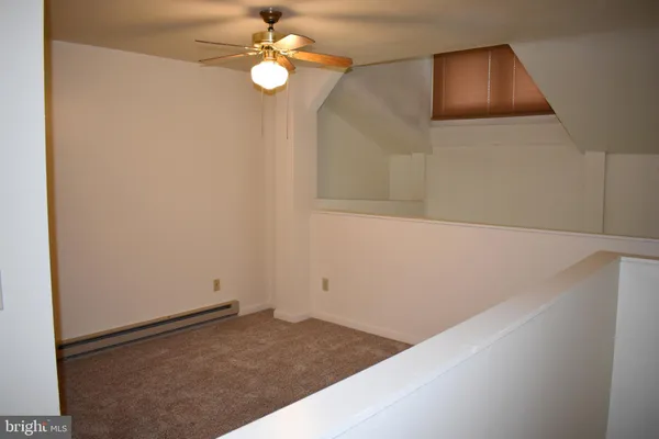 a view of a hallway with a chandelier fan