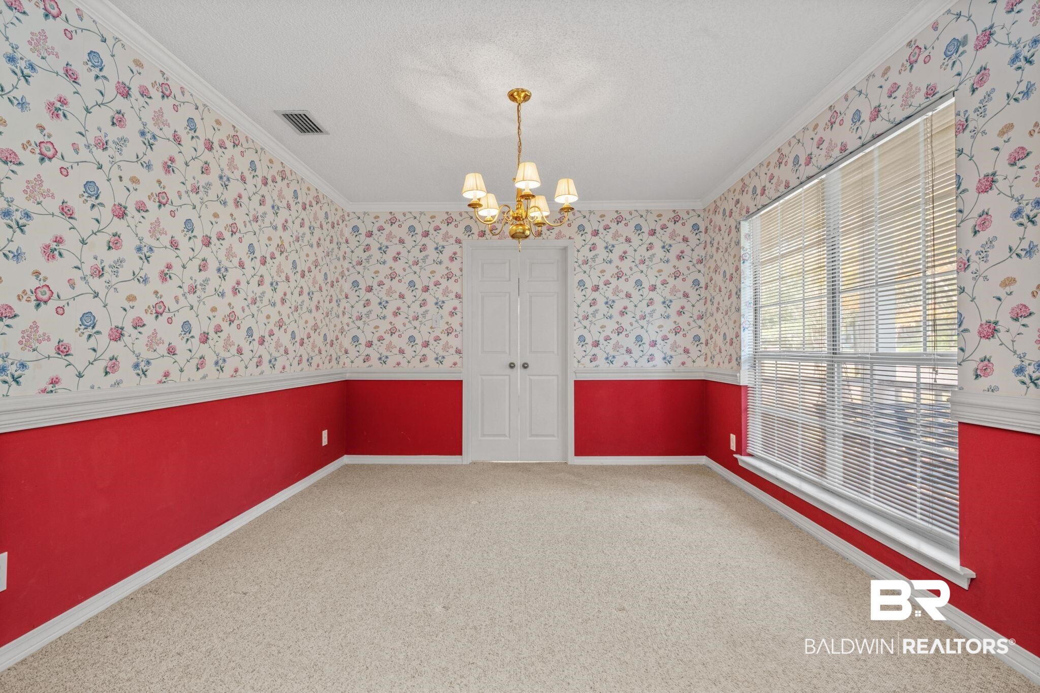 1340 Wellsley Court Mobile, AL 36695 - Photo 12 of 37 Carpeted empty room featuring ornamental molding, a chandelier, wallpapered walls, and a textured ceiling