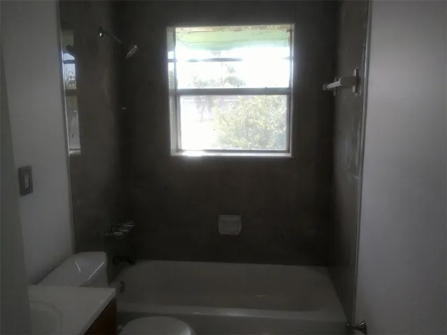 a bathroom with a toilet and a window
