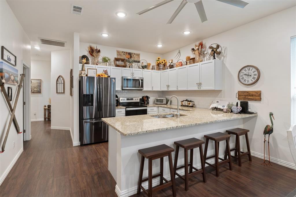 6156 Inca Drive Mabank, TX 75156 - Photo 12 of 30 a kitchen with stainless steel appliances granite countertop a refrigerator a stove top oven a sink and a island with wooden floor
