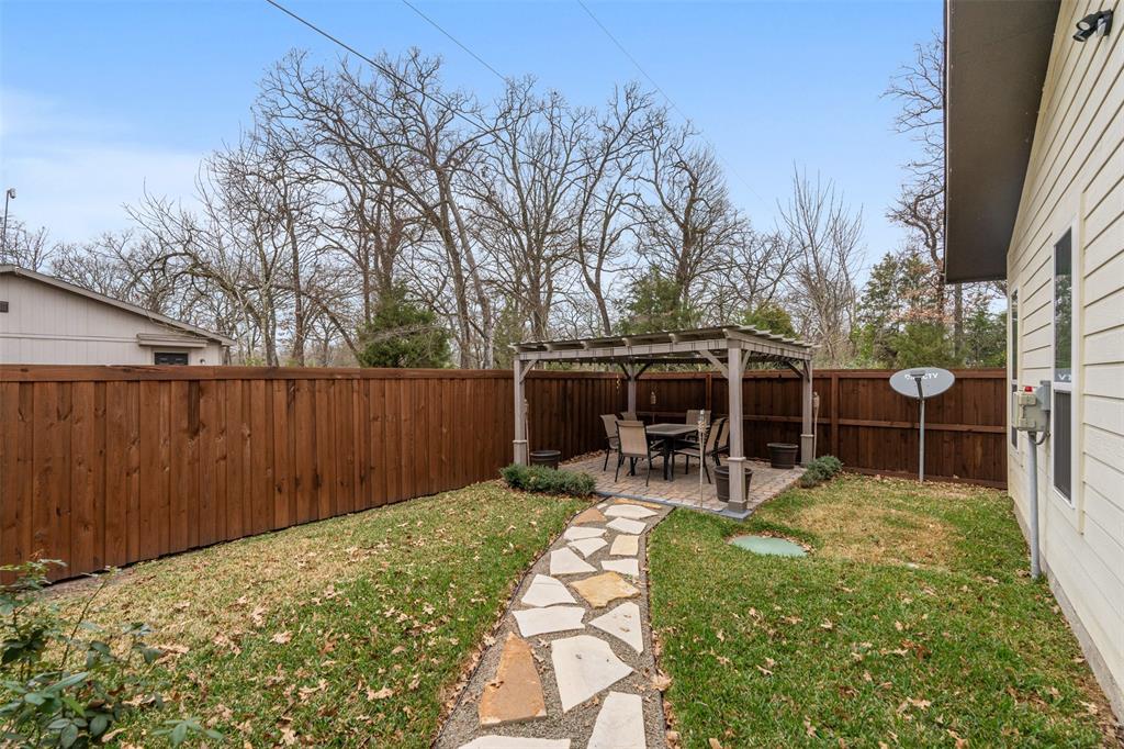 6156 Inca Drive Mabank, TX 75156 - Photo 26 of 30 a view of a backyard with table and chairs and wooden fence
