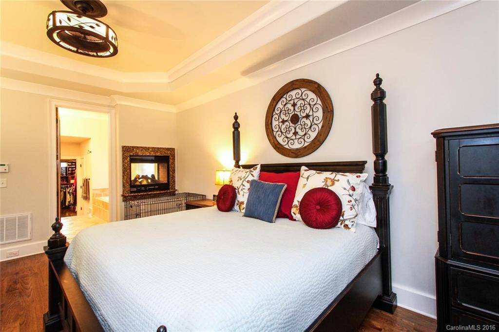 7227 Sheffingdell Drive Charlotte, NC 28226 - Photo 11 of 24 a bedroom with a bed and a chandelier