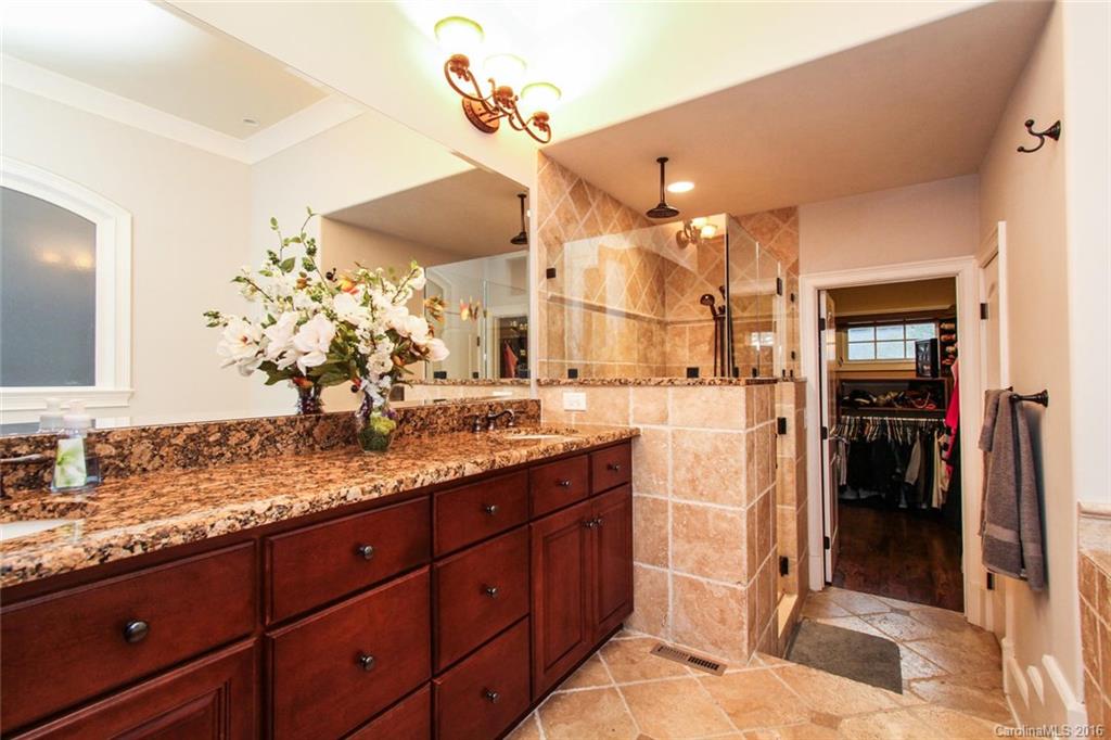 7227 Sheffingdell Drive Charlotte, NC 28226 - Photo 12 of 24 a spacious bathroom with a granite countertop sink a mirror and shower