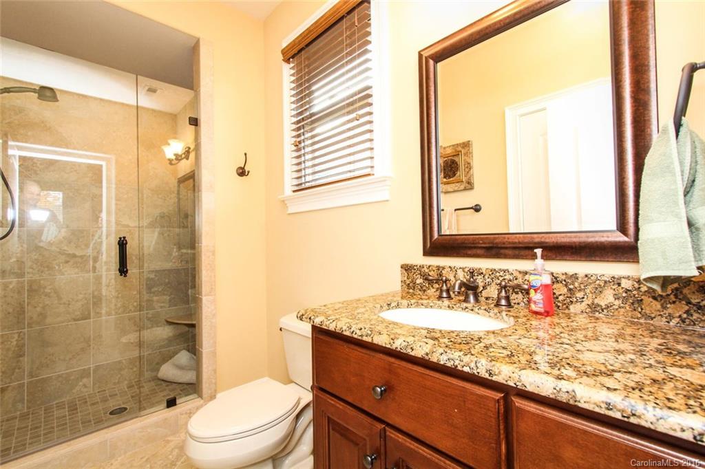 7227 Sheffingdell Drive Charlotte, NC 28226 - Photo 16 of 24 a bathroom with a granite countertop sink toilet a mirror and shower
