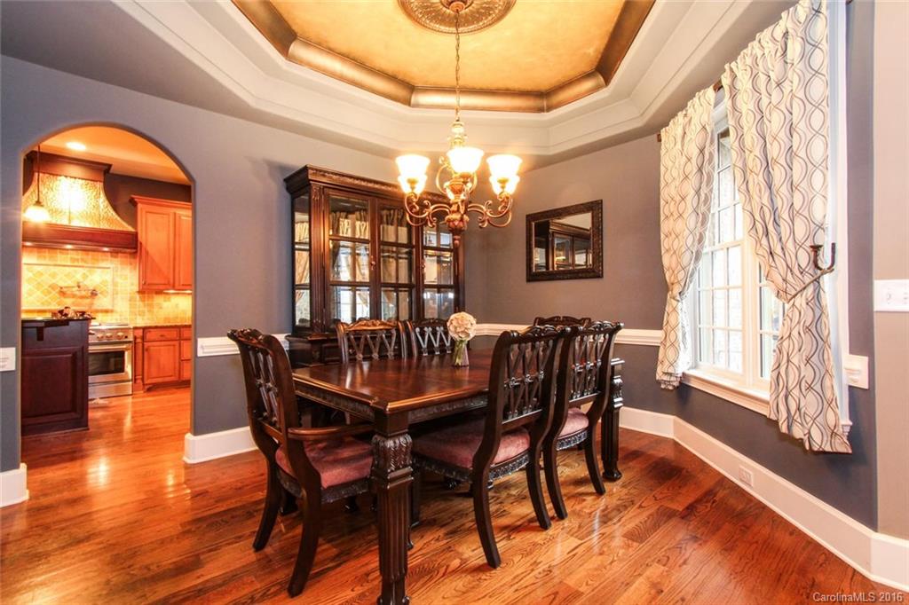 7227 Sheffingdell Drive Charlotte, NC 28226 - Photo 3 of 24 a dining room with furniture a chandelier and wooden floor