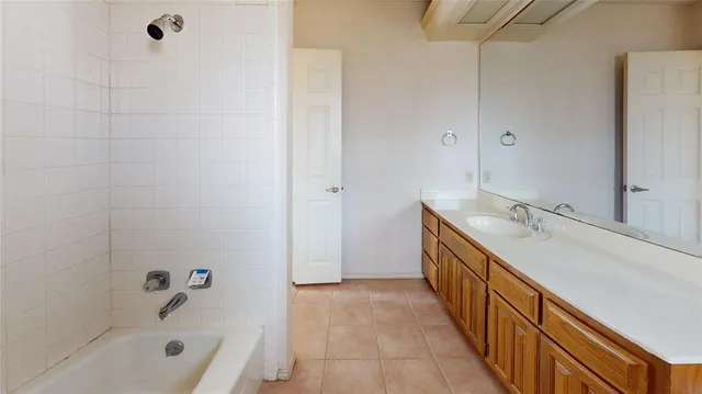 a bathroom with a double vanity sink a mirror and a bathtub