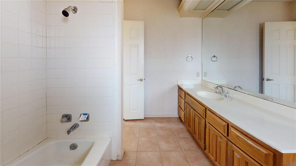 8927 Bontura Road Granbury, TX 76049 - Photo 20 of 23 a bathroom with a double vanity sink a mirror and a bathtub