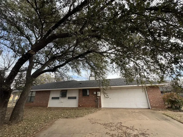 a front view of house with yard and trees