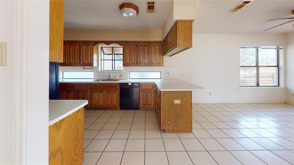 8927 Bontura Road Granbury, TX 76049 - Photo 7 of 23 a kitchen with stainless steel appliances a stove a sink and a refrigerator