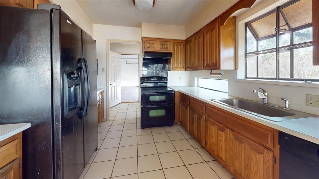 8927 Bontura Road Granbury, TX 76049 - Photo 8 of 23 a kitchen with stainless steel appliances granite countertop a refrigerator and a sink