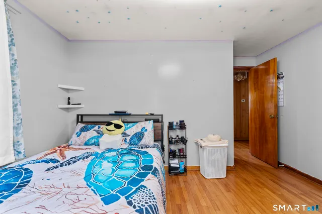 a bedroom with a bed and wooden floor