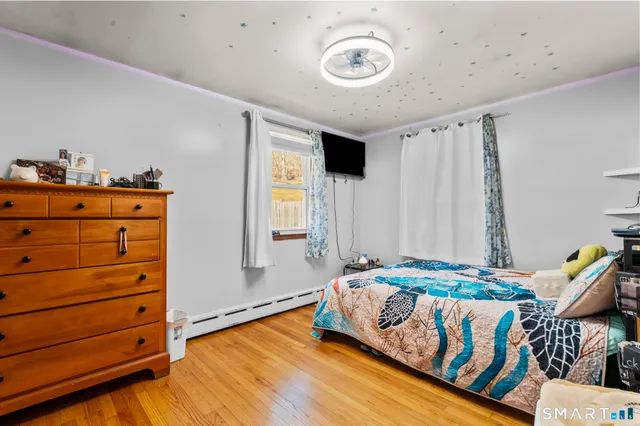 a bedroom with a bed and wooden floor