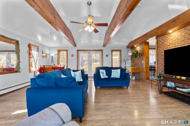 a living room with furniture a flat screen tv and a floor to ceiling window