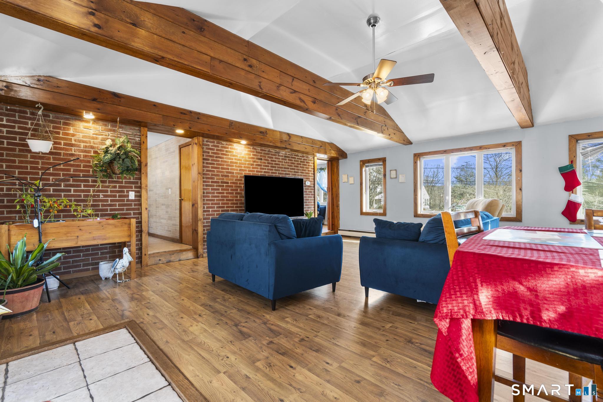 208 Bungay Road Seymour, CT 06483 - Photo 7 of 28 a living room with furniture a flat screen tv and a floor to ceiling window