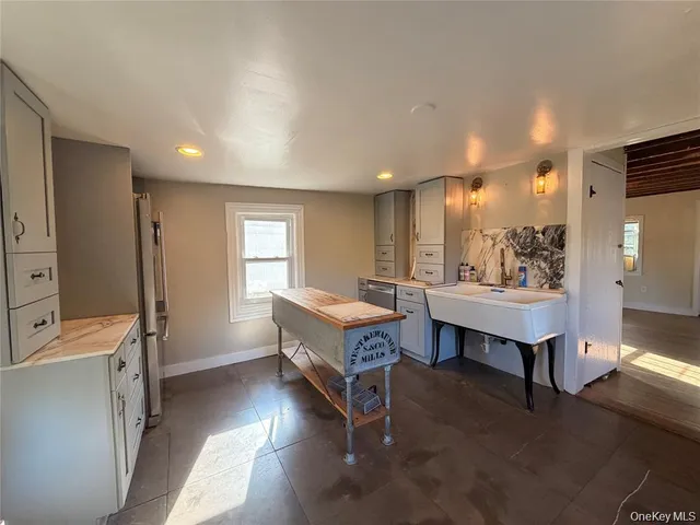 a living room with furniture a table and kitchen view