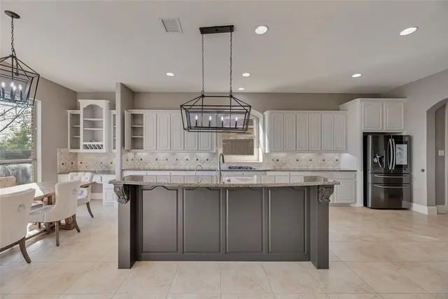 a kitchen with kitchen island a sink stainless steel appliances and cabinets