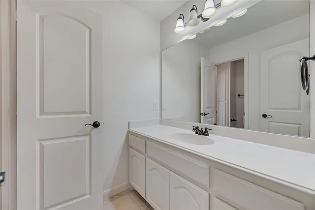 a bathroom with a sink vanity and a mirror