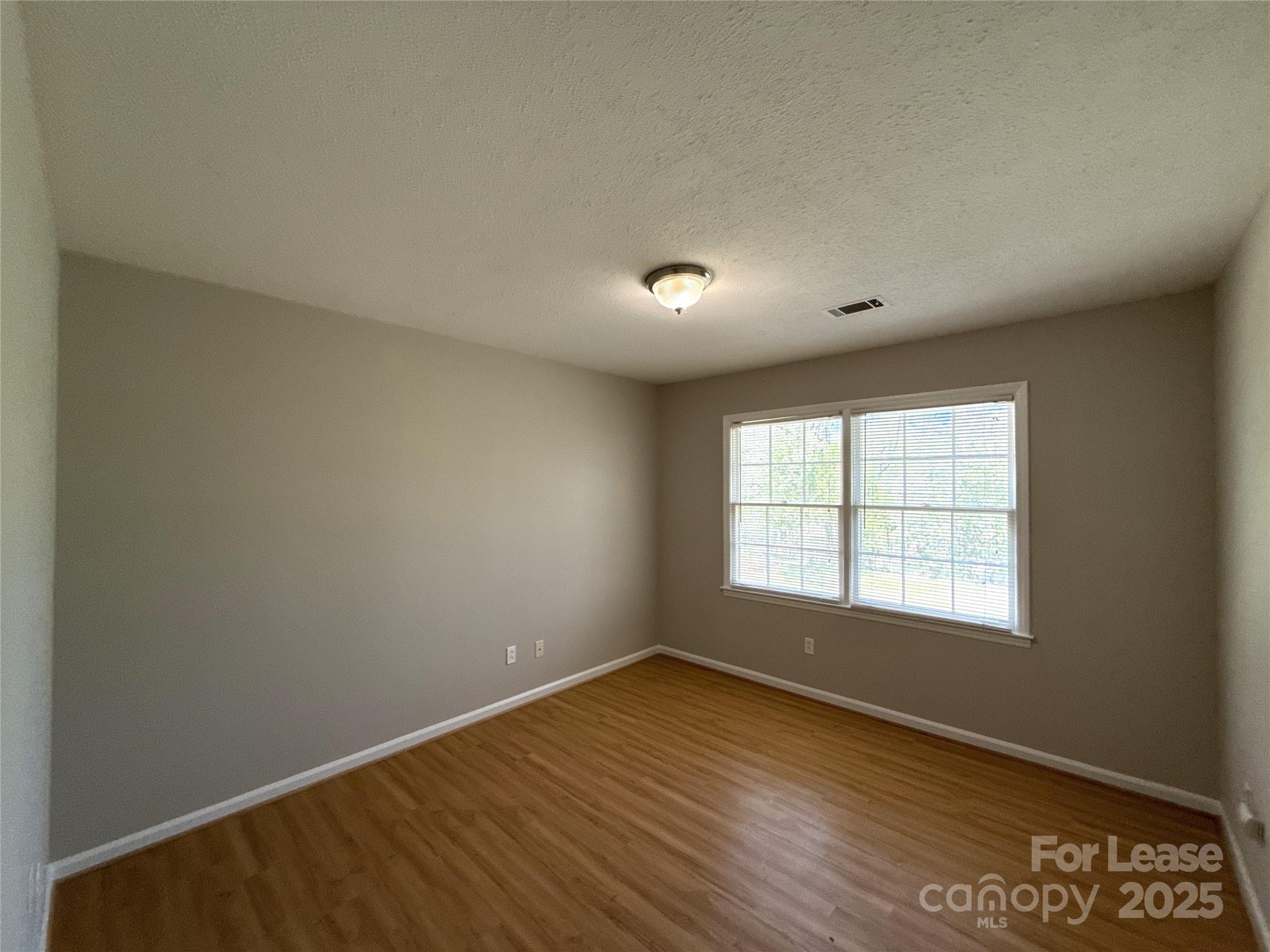 906 McLaughlin Drive Charlotte, NC 28212 - Photo 18 of 21 an empty room with wooden floor and windows