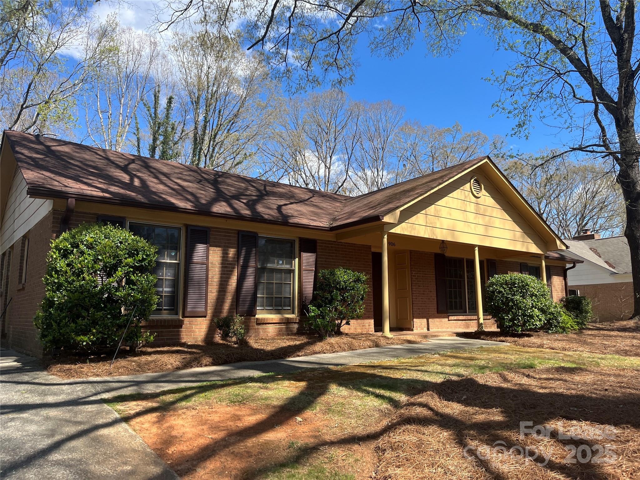 906 McLaughlin Drive Charlotte, NC 28212 - Photo 3 of 21 a view of a house with large windows and a tree with wooden fence