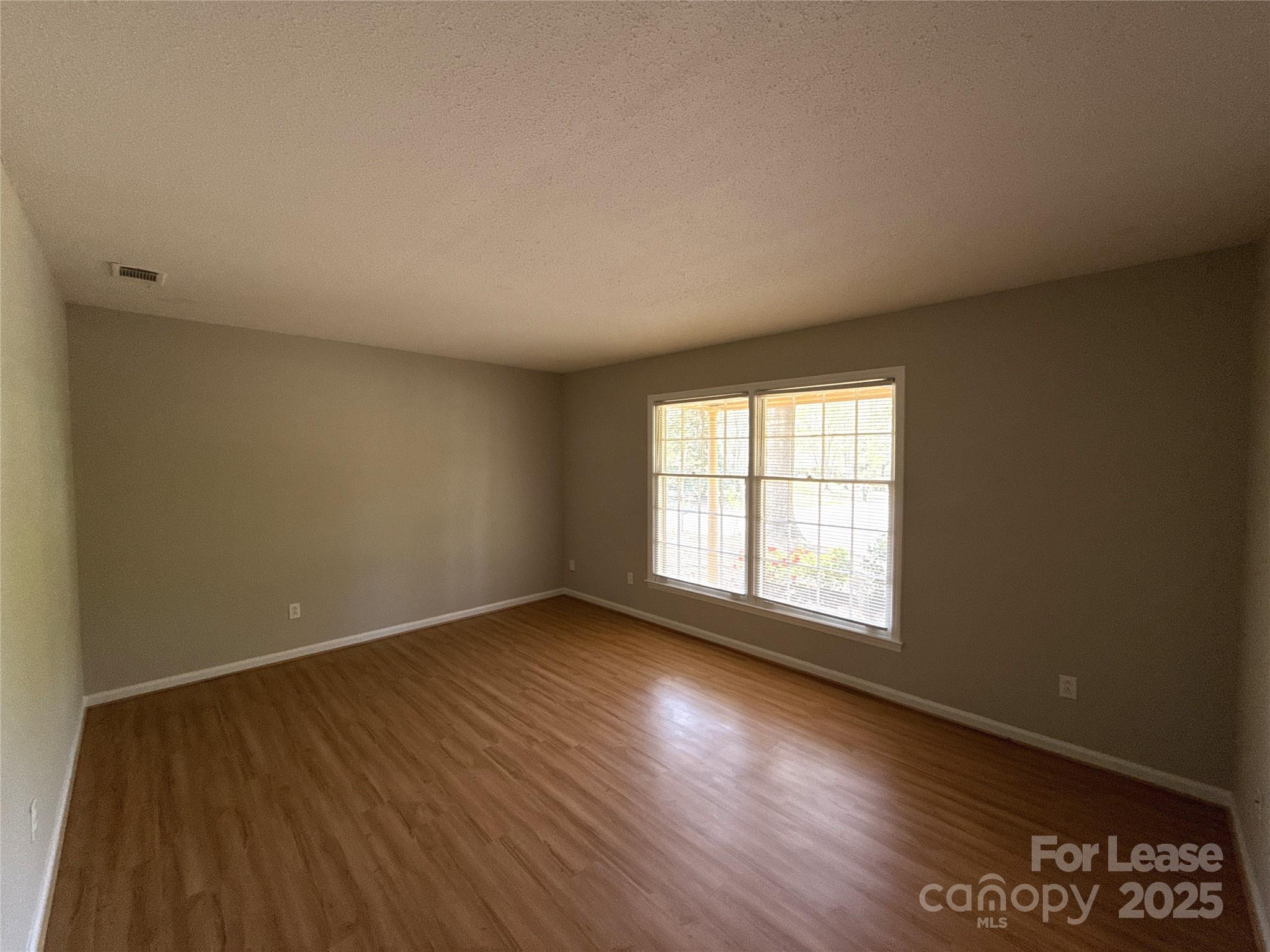 906 McLaughlin Drive Charlotte, NC 28212 - Photo 6 of 21 an empty room with wooden floor and windows