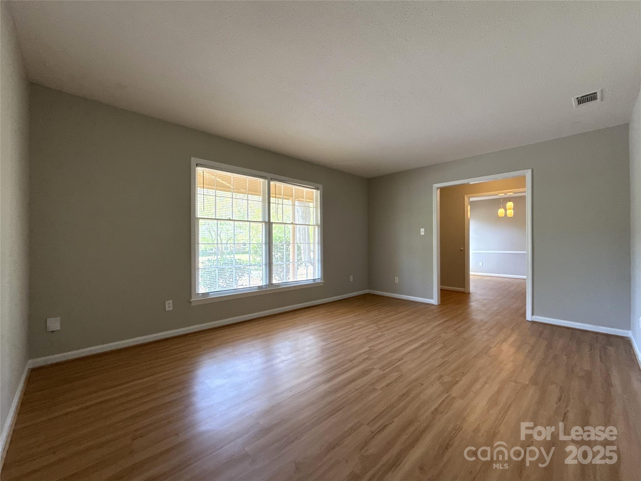 906 McLaughlin Drive Charlotte, NC 28212 - Photo 7 of 21 a view of an empty room with wooden floor and window