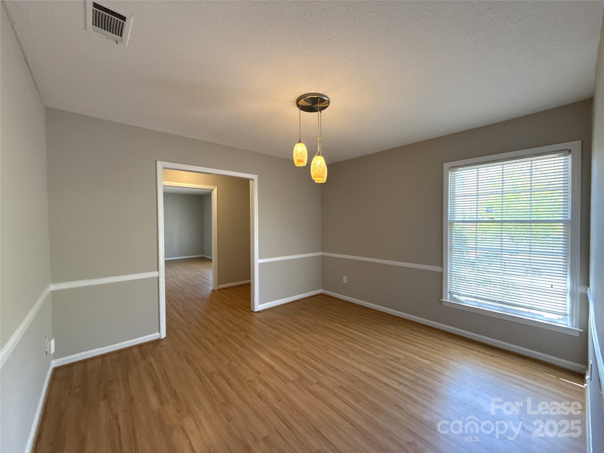 906 McLaughlin Drive Charlotte, NC 28212 - Photo 9 of 21 an empty room with wooden floor and windows