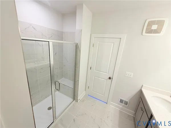 a bathroom with a shower and a glass door