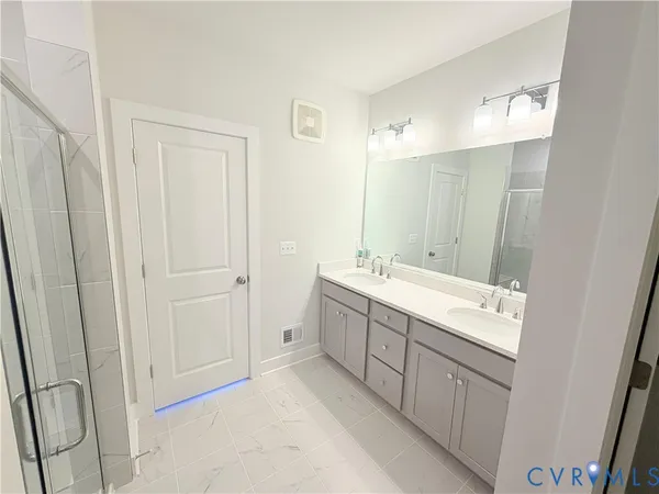 a bathroom with a double vanity sink and mirror