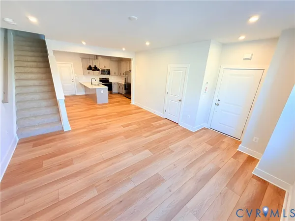 a view of a room with wooden floor and furniture