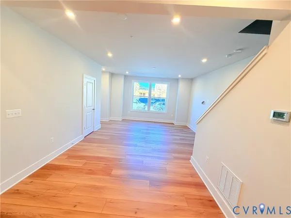 a view of an empty room with wooden floor