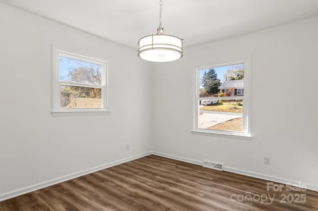 an empty room with window and wooden floor