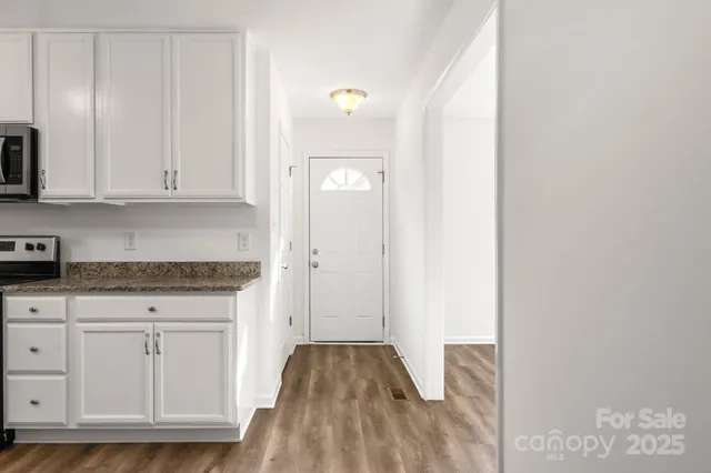 a view of kitchen with granite countertop cabinets and sink