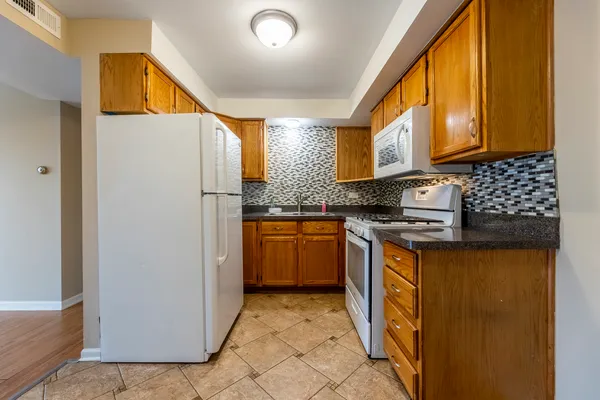 a kitchen with stainless steel appliances granite countertop a refrigerator and a stove top oven