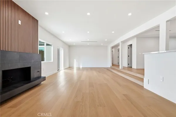 a view of empty room with wooden floor and fireplace