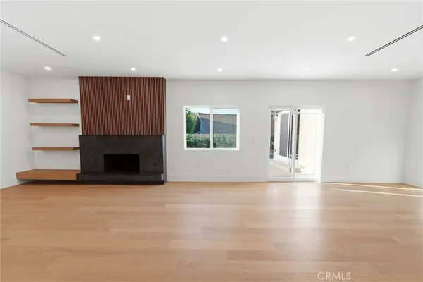 a view of an empty room with a fireplace and a window
